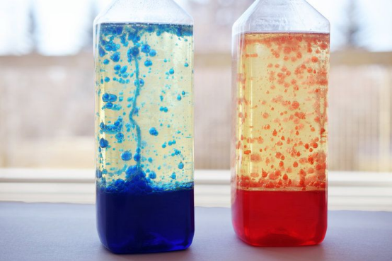 These bottle DIY lava lamps (blue and red) showcase the safe, simple kids’ science experiment.